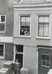 863400 Afbeelding van moeder en dochter Lever leunend uit een raam van hun bovenwoning Lange Koestraat 30 in Wijk C te ...